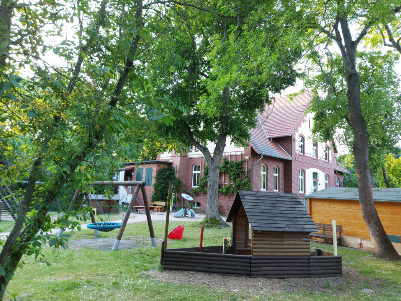 Spielgarten der Kita mit Haus und Spielgeräten
