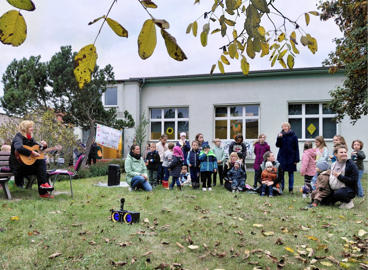 Kinder und Erwachsene bei einer Veranstaltung im Garten